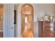 Hallway featuring arched doorway, hardwood floors, and stylish decor at 105 Wyndham Dr, Winter Haven, FL 33884