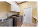 Well-equipped laundry room with modern washer, dryer, utility sink, and storage, making chores a breeze at 105 Wyndham Dr, Winter Haven, FL 33884