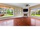 Cozy living room featuring hardwood floors, a fireplace, and large windows showcasing the outdoor landscape at 105 Wyndham Dr, Winter Haven, FL 33884