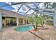 Screened-in pool, with a spa, palm trees, and an outdoor dining area at 105 Wyndham Dr, Winter Haven, FL 33884