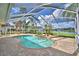 Screened in pool area, with a spa, palm trees, and water view at 105 Wyndham Dr, Winter Haven, FL 33884