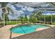 Screened-in pool and spa surrounded by palm trees and beautiful landscaping at 105 Wyndham Dr, Winter Haven, FL 33884
