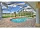 Screened-in pool with a spa, surrounded by palm trees, brick pavers, and a lake view at 105 Wyndham Dr, Winter Haven, FL 33884