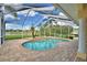 Screened-in pool with brick paver decking, a spa, and tropical landscaping at 105 Wyndham Dr, Winter Haven, FL 33884