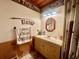 Charming bathroom featuring wood paneling, unique decor, and a vanity with ample storage at 1050 E Eagle Ave, Eagle Lake, FL 33839