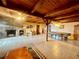 Large bonus room featuring a stone fireplace, exposed beams, and recreation area at 1050 E Eagle Ave, Eagle Lake, FL 33839
