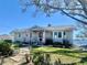 Charming single-story home with a stone pathway, inviting porch, and well-manicured lawn near the water at 1050 E Eagle Ave, Eagle Lake, FL 33839