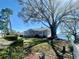 Single-story home featuring mature trees, charming front porch, and a lush lawn leading to the lake at 1050 E Eagle Ave, Eagle Lake, FL 33839