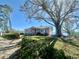 Single-story home featuring mature trees, charming front porch, and a lush lawn leading to the lake at 1050 E Eagle Ave, Eagle Lake, FL 33839