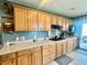 Kitchen featuring light wood cabinets, dark hardware, and a gas stovetop at 1050 E Eagle Ave, Eagle Lake, FL 33839