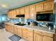 Spacious kitchen with wood cabinets, gas cooktop, ample countertop space, and neutral tile flooring at 1050 E Eagle Ave, Eagle Lake, FL 33839