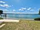 Beautiful lake view with a sandy beach and dock under a sunny, partly cloudy, blue sky at 1050 E Eagle Ave, Eagle Lake, FL 33839