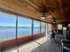 Spacious screened porch with tile flooring, wood ceilings, ceiling fans, and panoramic lake views at 1050 E Eagle Ave, Eagle Lake, FL 33839