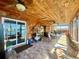 Spacious sunroom with wood ceiling, tile flooring, and access to outdoor area at 1050 E Eagle Ave, Eagle Lake, FL 33839