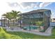 Stunning screened pool area with an outdoor television, palm trees, and outdoor seating at 1072 Bethpage Rd, Auburndale, FL 33823