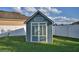 Backyard shed with double doors and a window, providing extra storage space and a touch of charm at 1072 Bethpage Rd, Auburndale, FL 33823