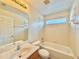 Bright bathroom features a tub-shower combo, integrated vanity, and a privacy window at 115 Argyle Gate Loop Rd, Dundee, FL 33838