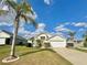 Charming single Gathering home with a two car garage, landscaped yard, and mature palm trees at 115 Argyle Gate Loop Rd, Dundee, FL 33838