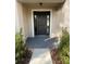 Inviting front entryway with a sleek black door flanked by sidelights and manicured landscaping at 1205 Lake Loop Rd, Winter Haven, FL 33880