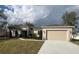 Attractive single-story home featuring a two-car garage, neutral stucco, well-maintained lawn, and simple landscaping at 1205 Lake Loop Rd, Winter Haven, FL 33880