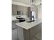 Modern kitchen boasts stainless steel appliances, gray cabinetry, quartz countertops, and an island with a sink at 1205 Lake Loop Rd, Winter Haven, FL 33880