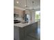Stylish kitchen featuring a large island, quartz countertops, pendant lighting, and stainless steel appliances at 1205 Lake Loop Rd, Winter Haven, FL 33880