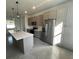Well-appointed kitchen featuring stainless steel appliances, shaker cabinets, quartz counters, and sleek pendant lighting at 1205 Lake Loop Rd, Winter Haven, FL 33880