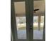 Covered back patio with a ceiling fan visible through the glass doors overlooking a fenced yard at 1205 Lake Loop Rd, Winter Haven, FL 33880