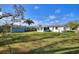Expansive backyard with lush green grass, a storage shed, and an enclosed patio attached to the home at 1229 Rawls Dr, Lakeland, FL 33801
