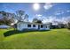 Well-maintained single-story home featuring a lush green lawn and mature trees under a sunny sky at 1229 Rawls Dr, Lakeland, FL 33801