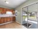 Spacious kitchen with tiled floor, wood cabinets, and access to screened porch at 1229 Rawls Dr, Lakeland, FL 33801