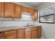 Cozy kitchen featuring wood cabinets, granite countertops, a stainless sink and white tiled backsplash at 1229 Rawls Dr, Lakeland, FL 33801