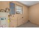 Utility room featuring water heater, electrical panel, and window providing natural light at 1233 Rawls Dr, Lakeland, FL 33801