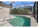 Swimming pool with clear water and tropical landscaping beyond the screen enclosure at 126 Seneca Ln, Davenport, FL 33897