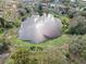 Stunning aerial view of a tranquil pond surrounded by lush greenery and neighborhood homes at 128 Lake Ring Dr, Winter Haven, FL 33884