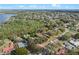 An aerial view of a home in a quiet neighborhood near a lake, showcasing mature trees and lush landscaping at 128 Lake Ring Dr, Winter Haven, FL 33884