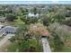 Aerial view of home with tile roof, surrounded by mature trees in a neighborhood setting at 128 Lake Ring Dr, Winter Haven, FL 33884