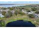 Scenic aerial view of a home by the lake, surrounded by lush greenery and neighborhood charm at 128 Lake Ring Dr, Winter Haven, FL 33884