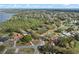 Aerial view of residential area with lake in distance and tree covered neighborhood at 128 Lake Ring Dr, Winter Haven, FL 33884