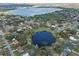 Aerial view of the neighborhood featuring two ponds, a lake, mature trees, and many single Gathering homes at 128 Lake Ring Dr, Winter Haven, FL 33884