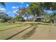 Large backyard with mature trees offering shade with a view of the house at 128 Lake Ring Dr, Winter Haven, FL 33884