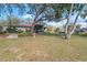 Spacious backyard with mature trees, a patio, and views of the house and lush surroundings at 128 Lake Ring Dr, Winter Haven, FL 33884