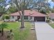 Exterior elevation of home featuring a tile roof, an attached garage, and a well-maintained front yard at 128 Lake Ring Dr, Winter Haven, FL 33884