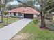 Exterior elevation of home showcasing a tile roof, an attached garage, and a well-maintained front yard at 128 Lake Ring Dr, Winter Haven, FL 33884