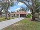Exterior elevation of home featuring a tile roof, well-manicured lawn, and a basketball hoop in the driveway at 128 Lake Ring Dr, Winter Haven, FL 33884