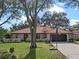 Exterior elevation of home showcasing a tile roof, an attached garage, and a well-maintained front yard at 128 Lake Ring Dr, Winter Haven, FL 33884