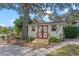 Outbuilding with a charming design, complemented by a playset, lush greenery and a lakeside setting at 128 Lake Ring Dr, Winter Haven, FL 33884