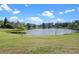 Scenic view of a picturesque pond surrounded by lush green grass and trees at 128 Lake Ring Dr, Winter Haven, FL 33884