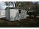 Exterior shot of a white storage shed with a window and a corrugated metal roof at 130 Alvina Ave, Lake Wales, FL 33853