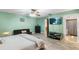 Bright bedroom features wood-look floors, a ceiling fan and a television mounted on the wall at 15 Casarena Ct, Winter Haven, FL 33881